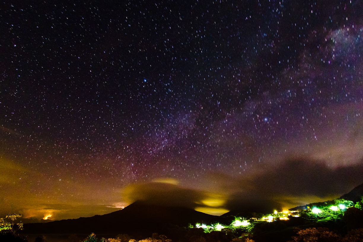 Volcán Arenal, cloaked in cloud, with lightning bolts erupted to the left, starfields multiplying above, and the quiet goings-on of local Costa Rican villagers beneath.Technically not a great starscape, but my first ever attempt back in 2011 and left the exposure running for too long (101 seconds) and was so captivated by the open skies that I didn't re-take this view.  Fond memories, though.Development notes: this uses a graduated filter added in post, and a wire has been cloned out of the lower left corner.